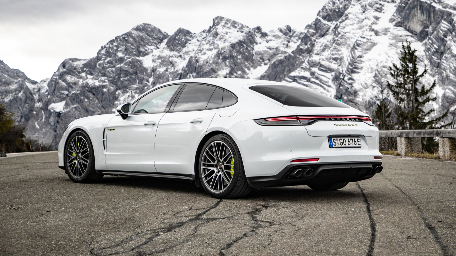 Белый автомобиль Porsche Panamera Turbo S E-Hybrid 2021 года на фоне гор