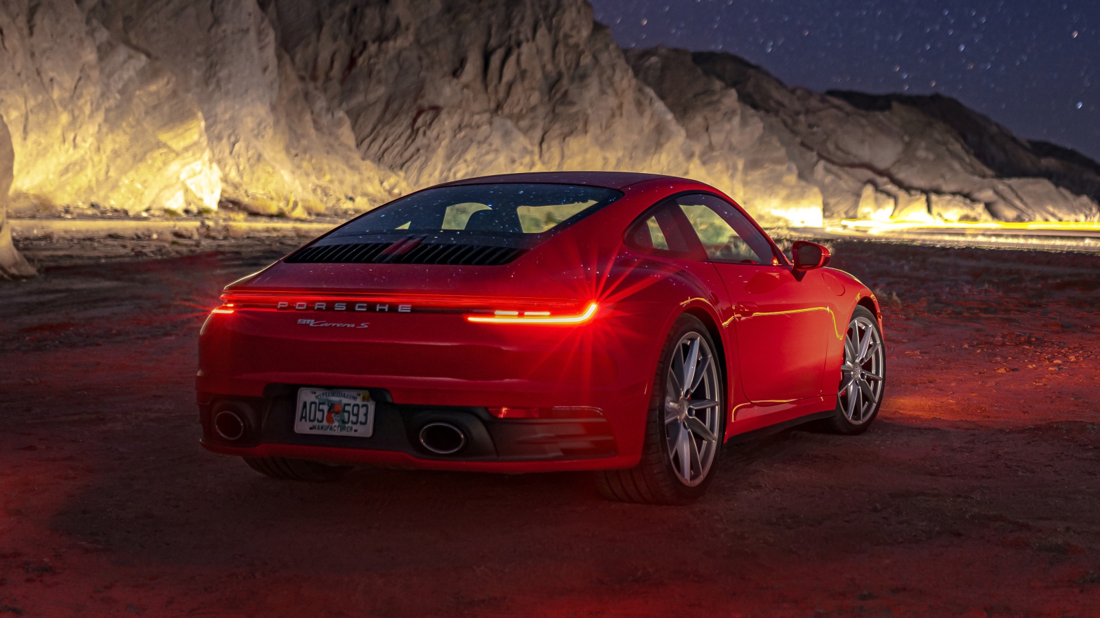 Красный автомобиль  Porsche 911 Carrera S, 2020 года в горах ночью 