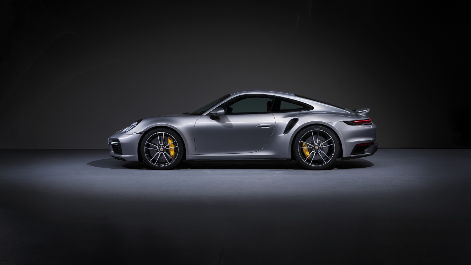 Серебристый автомобиль Porsche 911 Turbo S 2020 года вид сбоку 