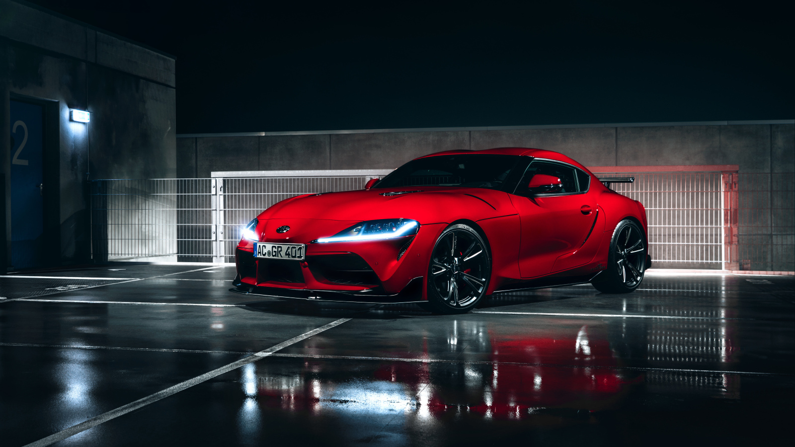 Красный автомобиль Toyota GR Supra AC Schnitzer 2019 года у гаража