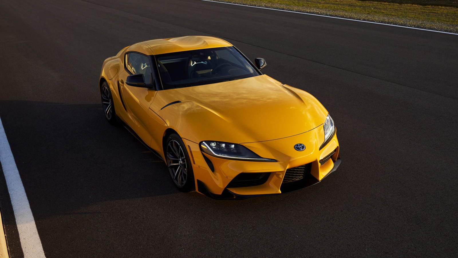 Желтый автомобиль  Toyota GR Supra, 2021 года на трассе 