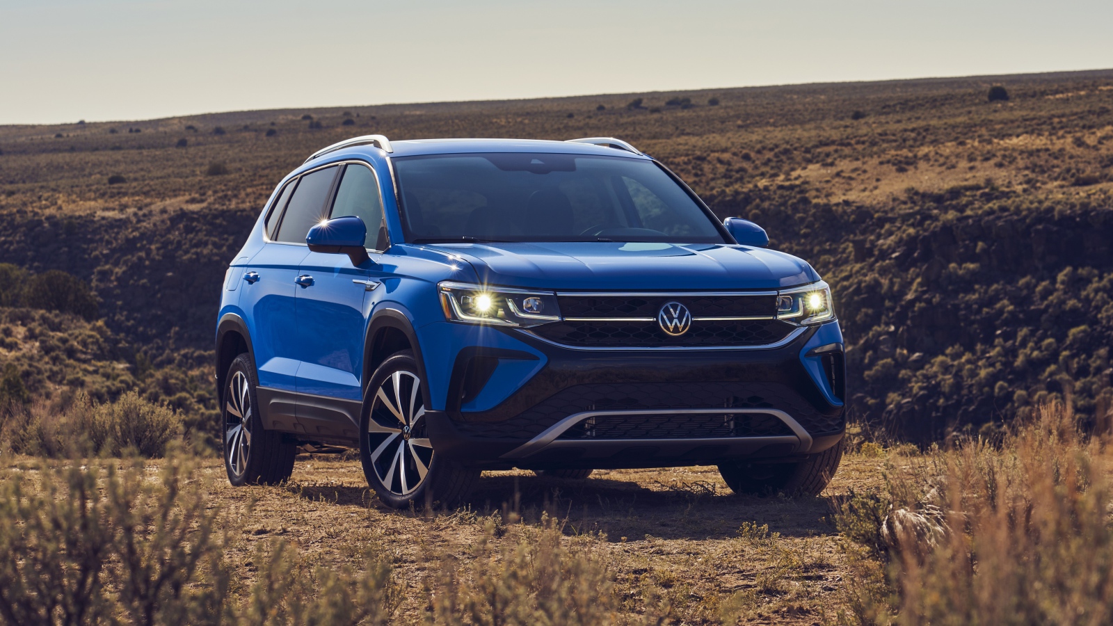 Синий автомобиль  Volkswagen Taos, 2022 года на поле 