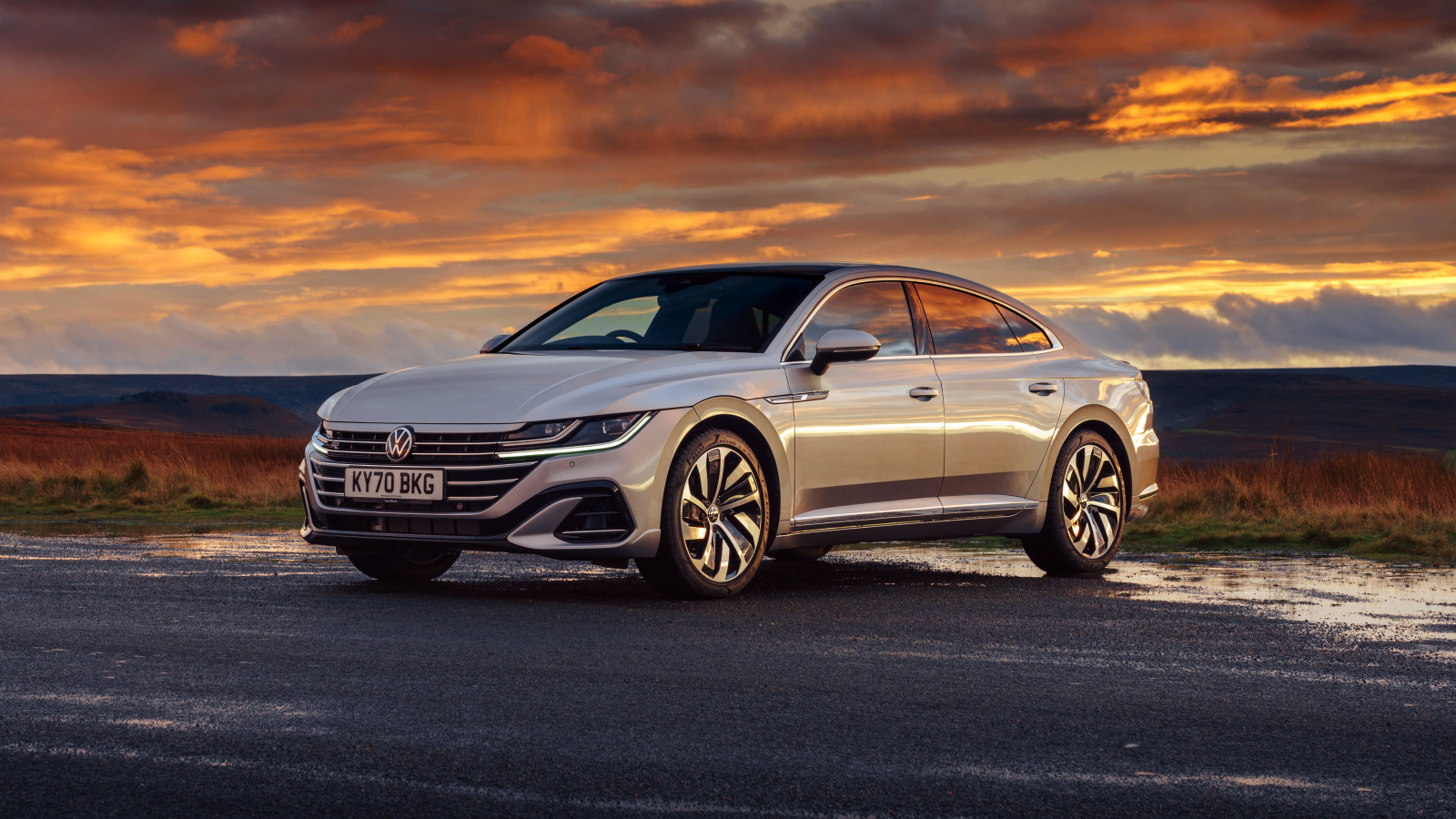 Серебристый автомобиль Volkswagen Arteon R-Line 2020 года на закате