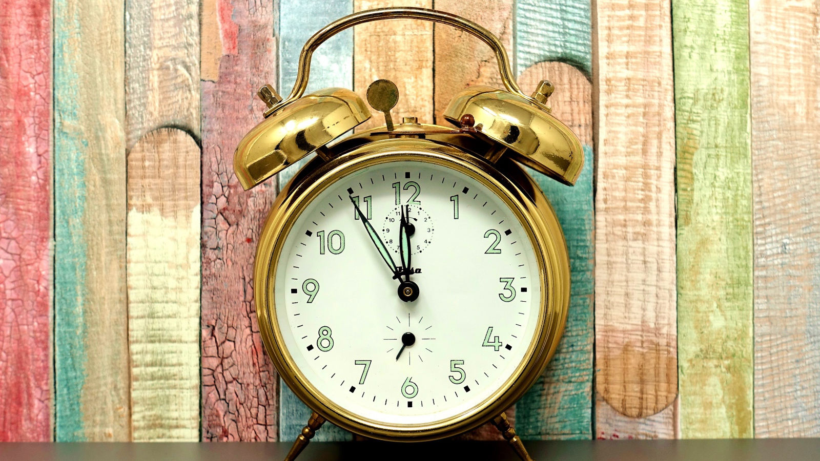 Золотой будильник стоит у стены 