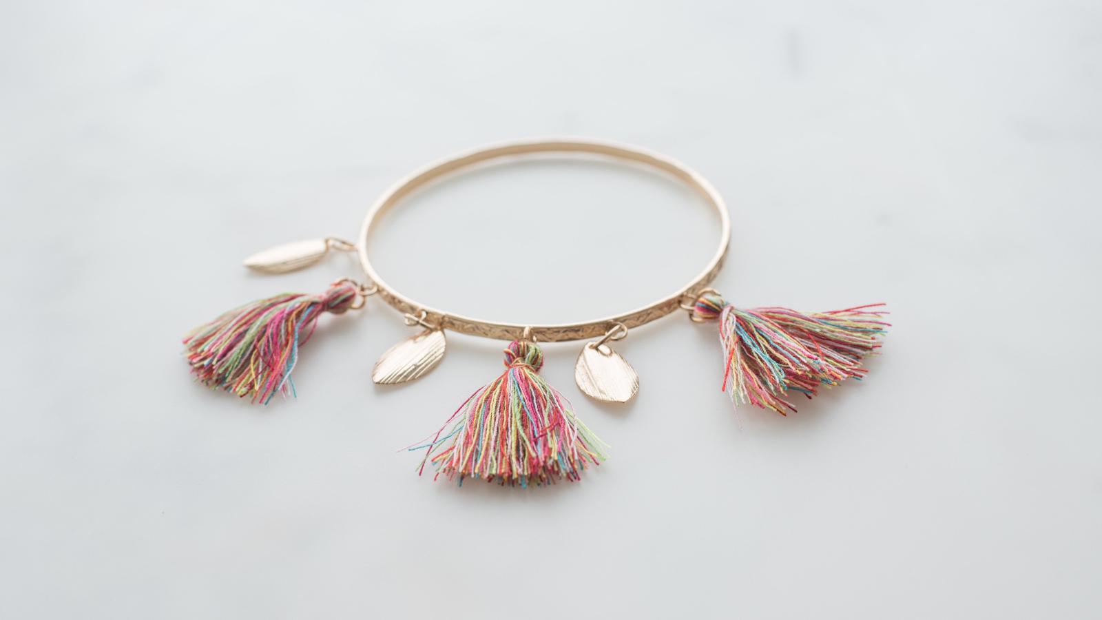 Золотой браслет на сером фоне