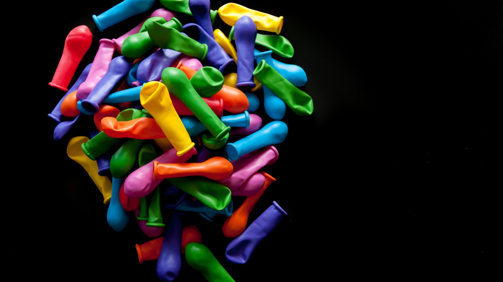 Много разноцветных шариком на черном фоне 