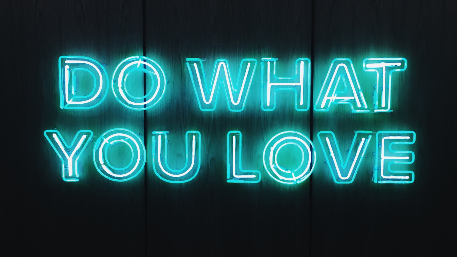 Неоновая надпись Do What You Love на деревянном фоне