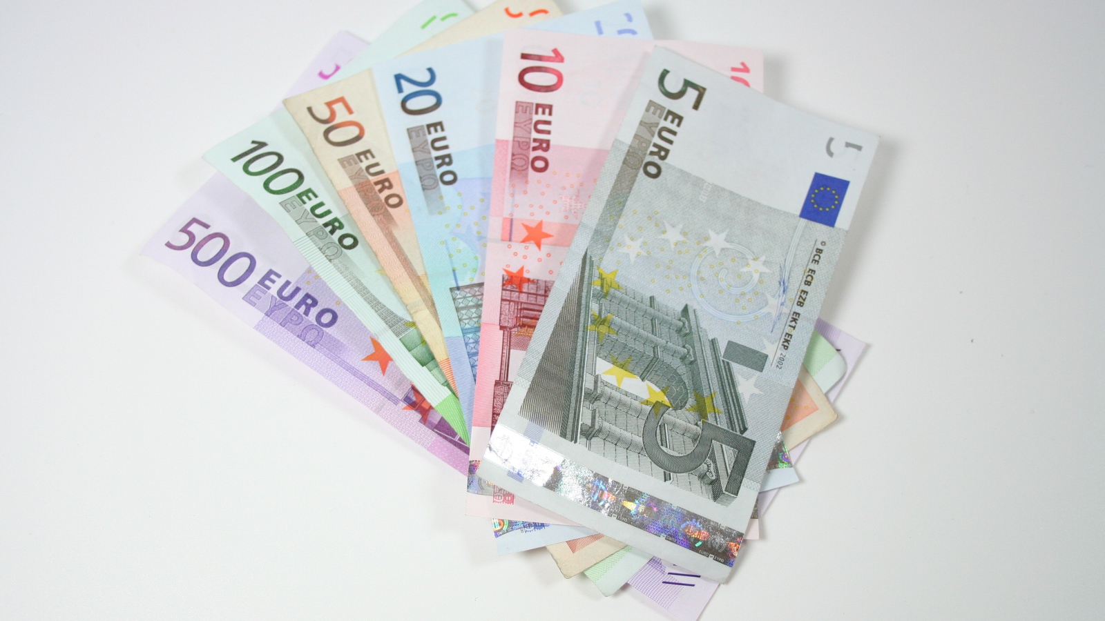 Купюры евро разным номиналом на сером фоне