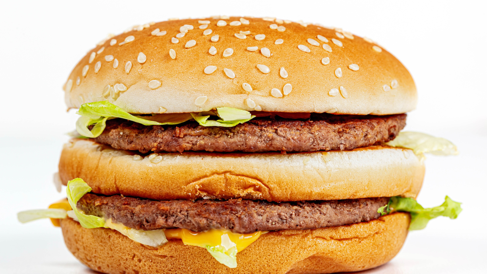 Большой аппетитный гамбургер на белом фоне