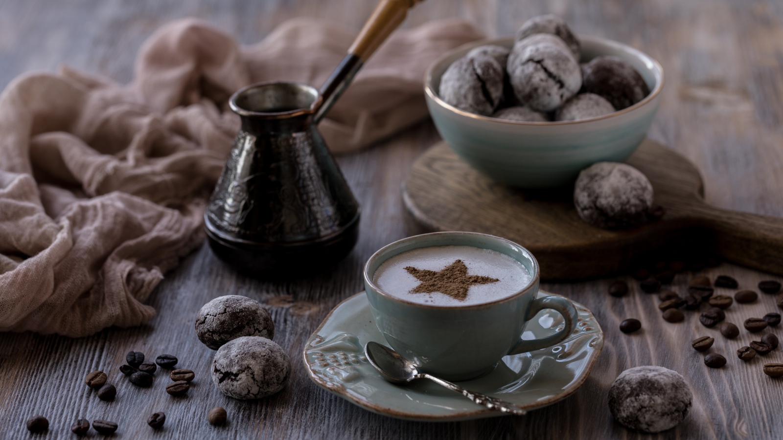 Чашка кофе на столе с пряниками и зернами