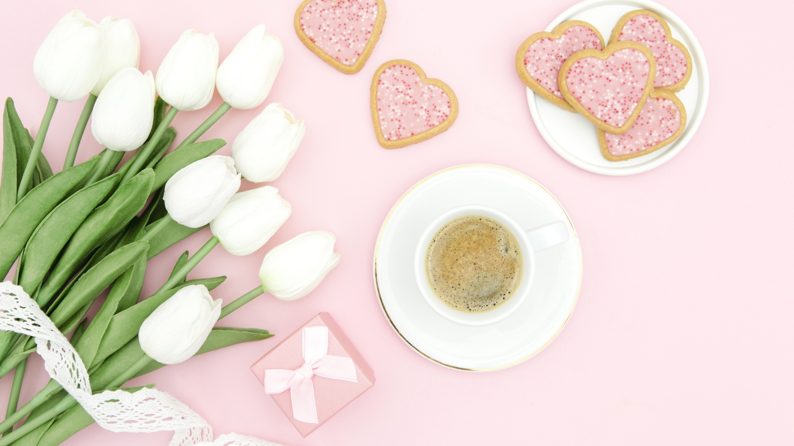 Чашка кофе с печеньем на столе с букетом белых тюльпанов