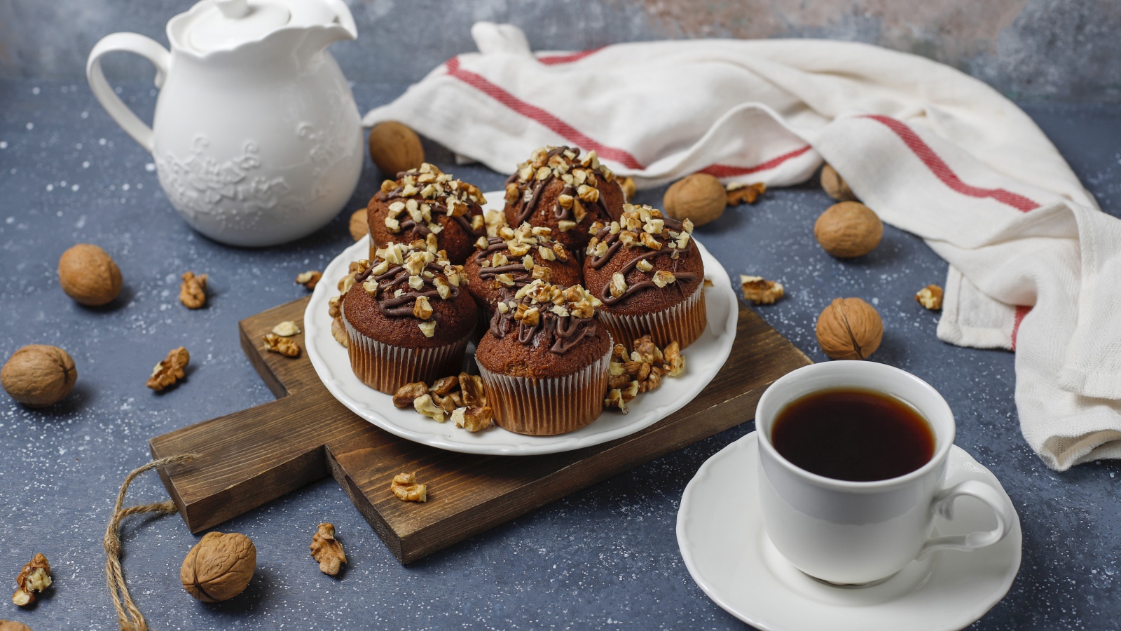 Вкусные шоколадные кексы с орехами на столе с кофе