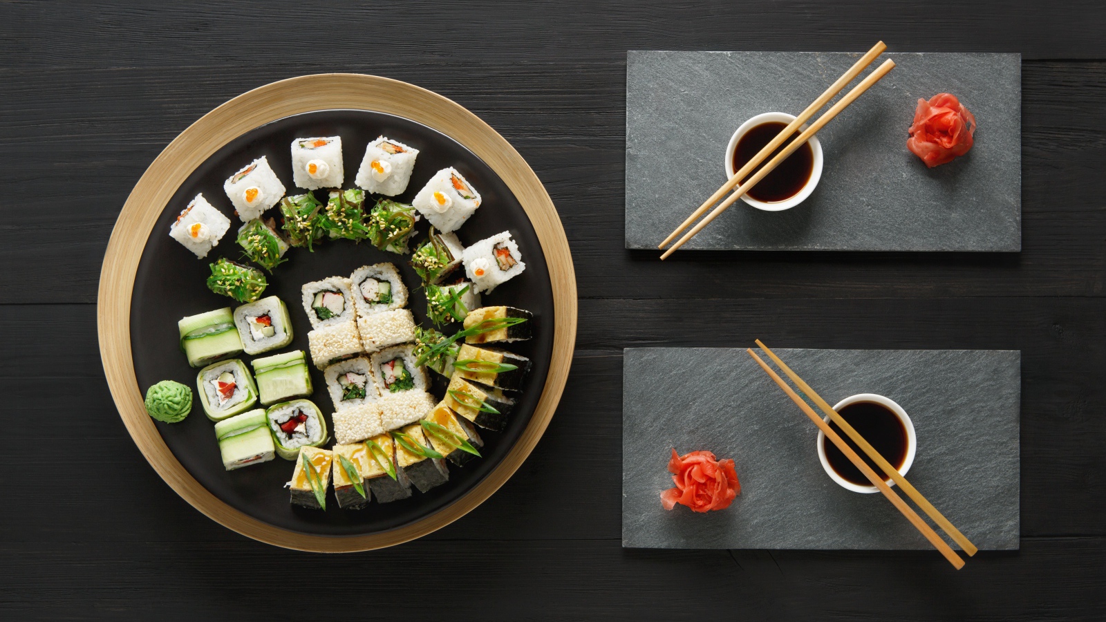 Вкусные  роллы на столе с соевым соусом и палочками 