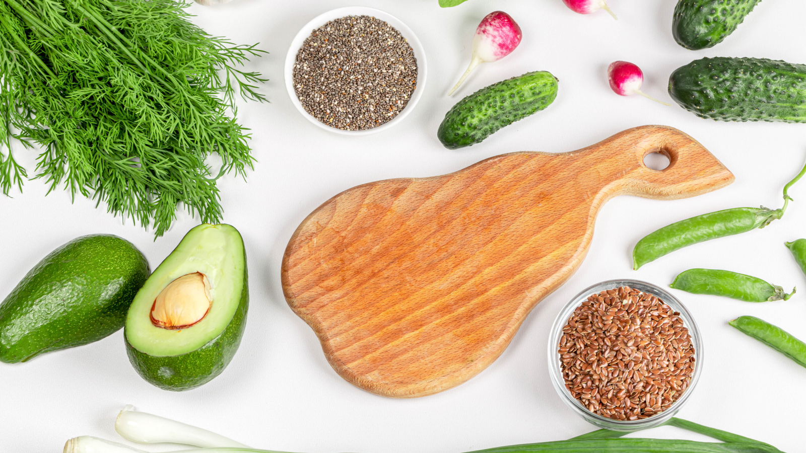 Свежие огурцы, авокадо, редис и укропом на столе с зернами
