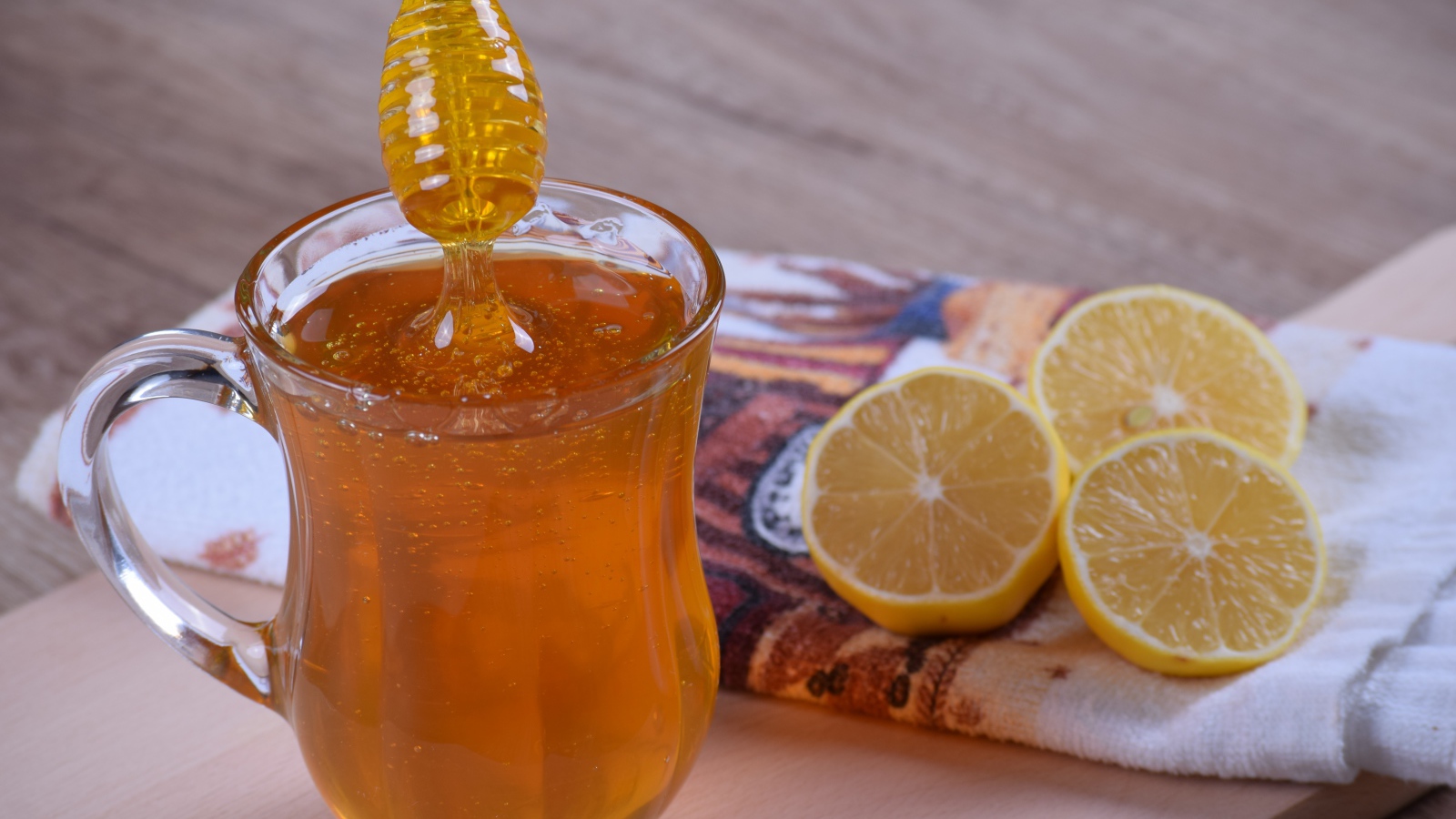 Стеклянная кружка с медом на столе с лимоном