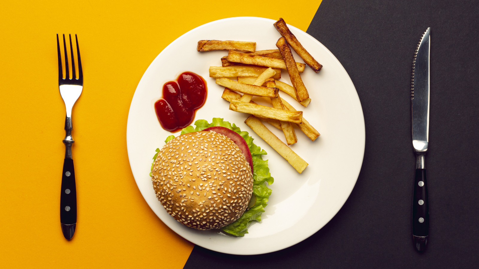 Гамбургер на белой тарелке с соусом и картофелем фри