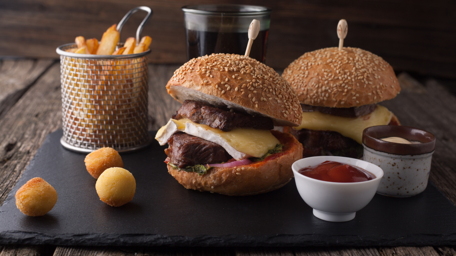 Гамбургеры с мясо на столе с картофелем фри и соусом