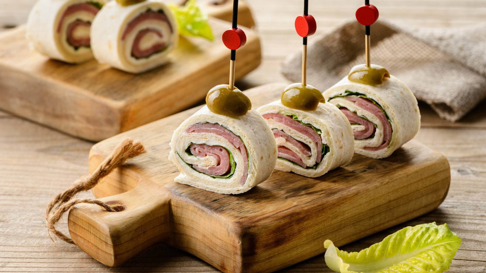 Рулетики из лаваша с ветчиной на столе 