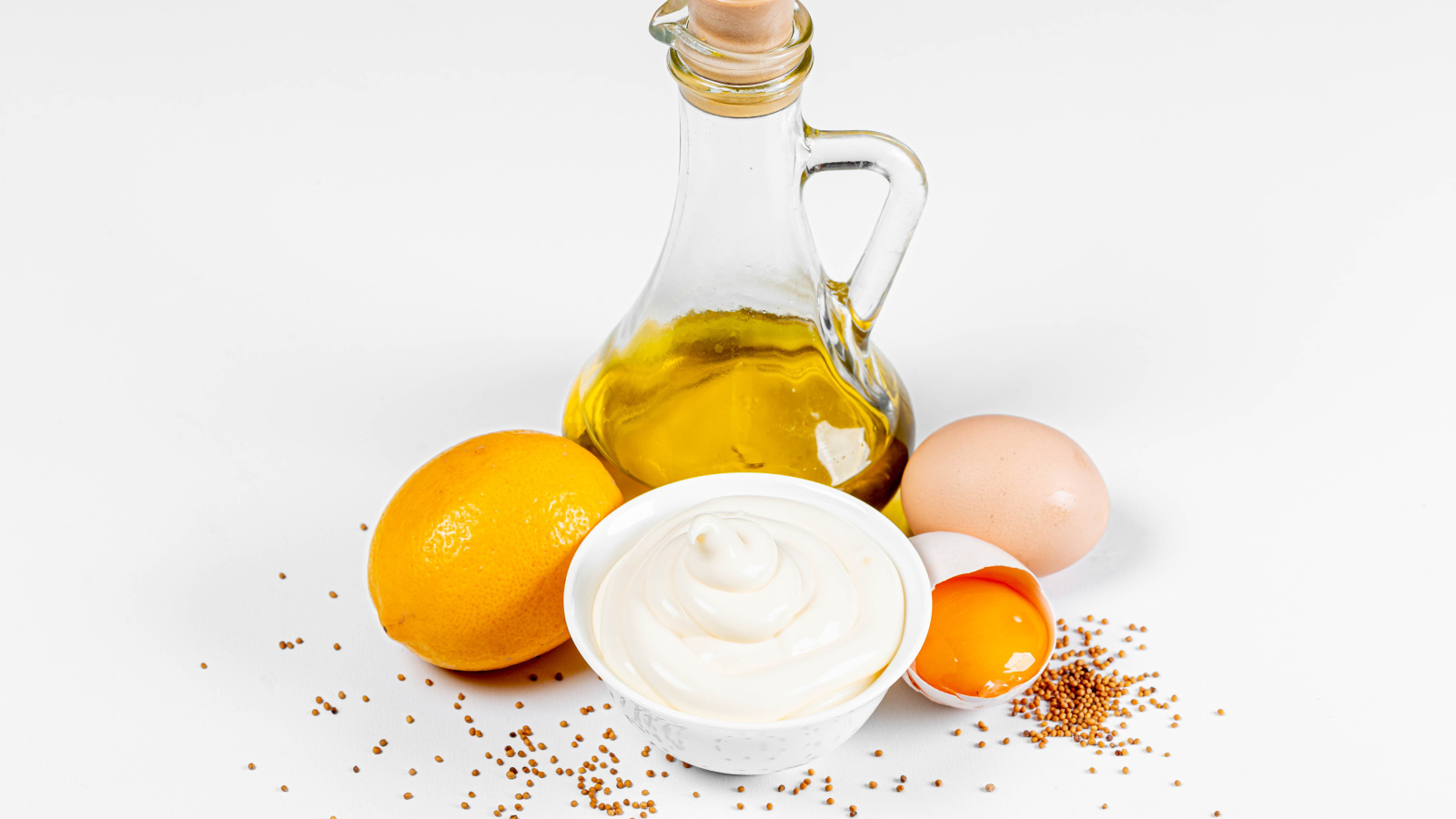 Оливковое масло, яйца и лимон на белом фоне с майонезом