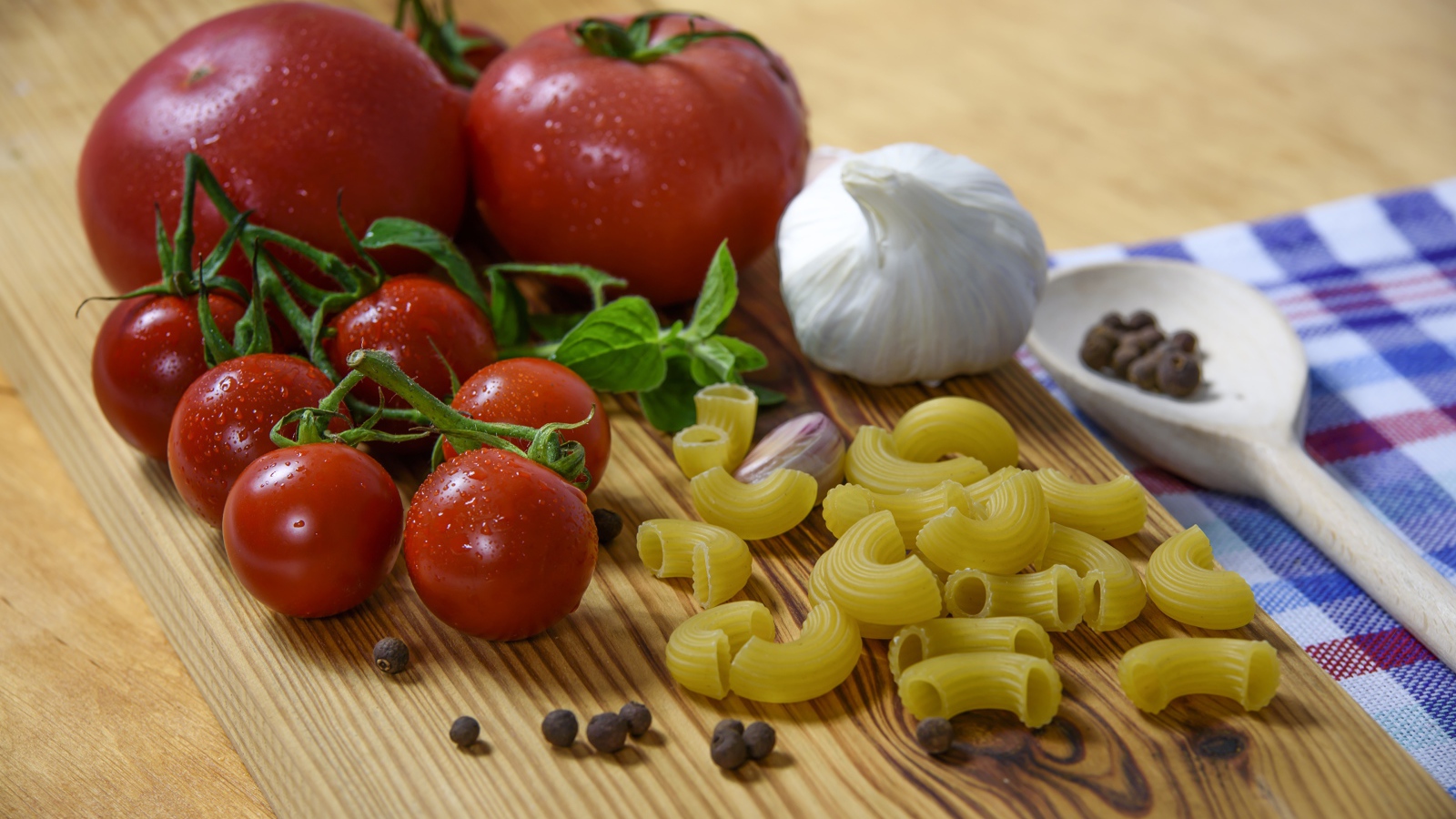 Макароны на столе с помидорами и чесноком