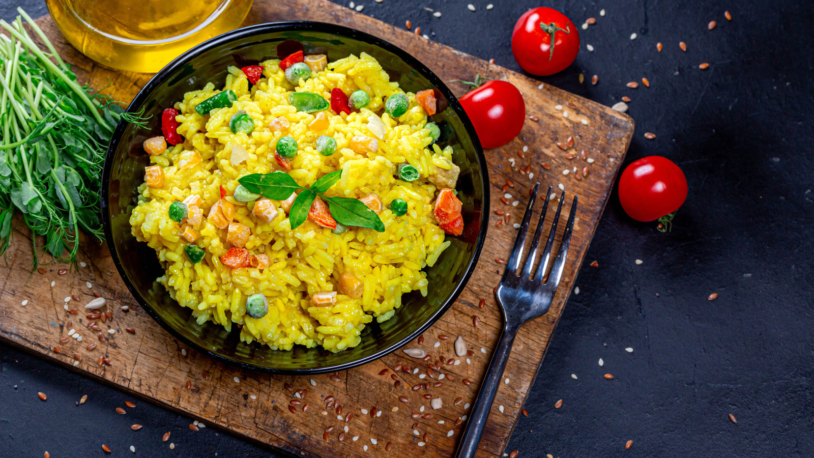 Рис с овощами на столе с маслом, зеленью и помидорами 