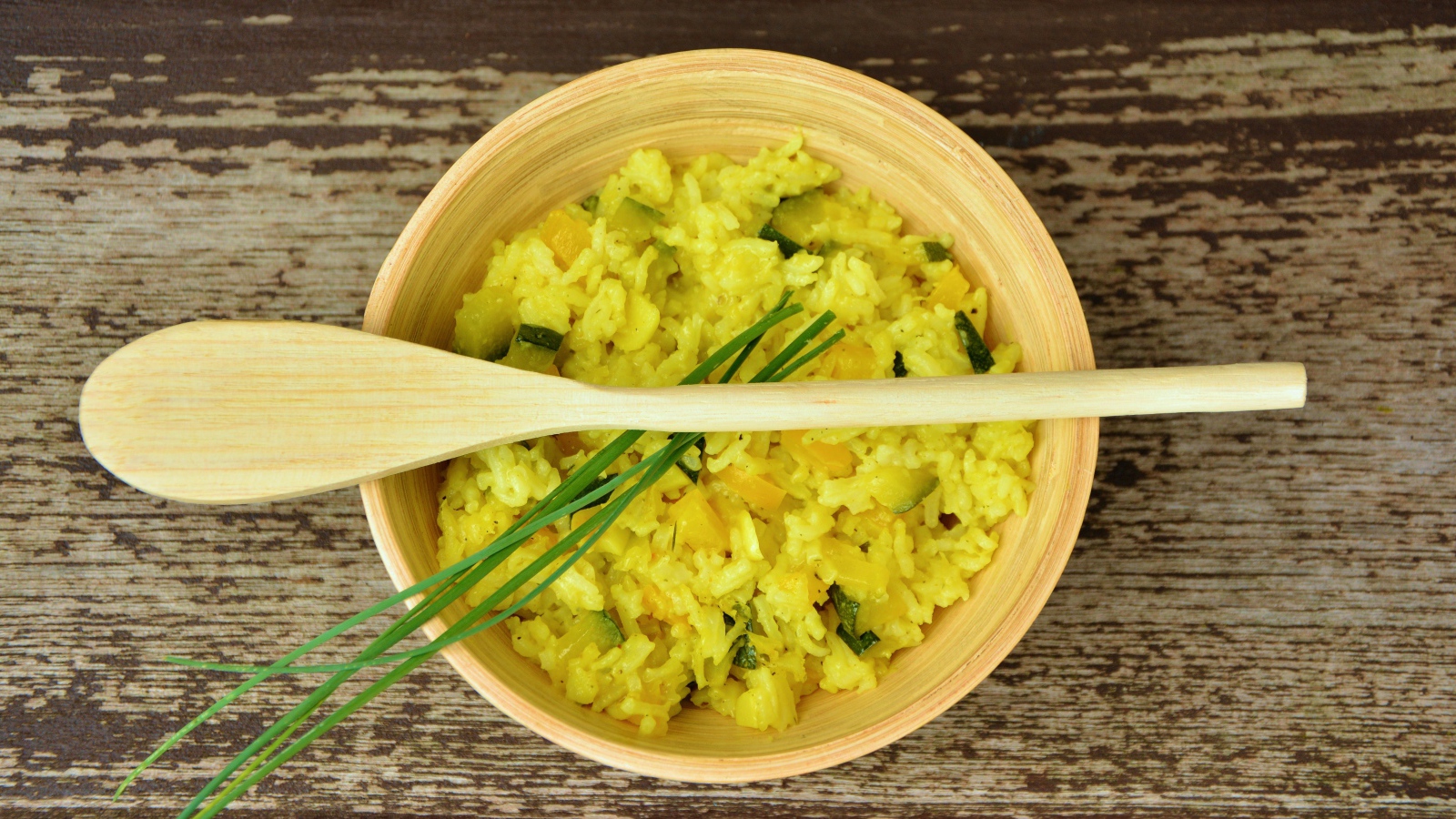 Блюдо ризотто в деревянной миске с ложкой