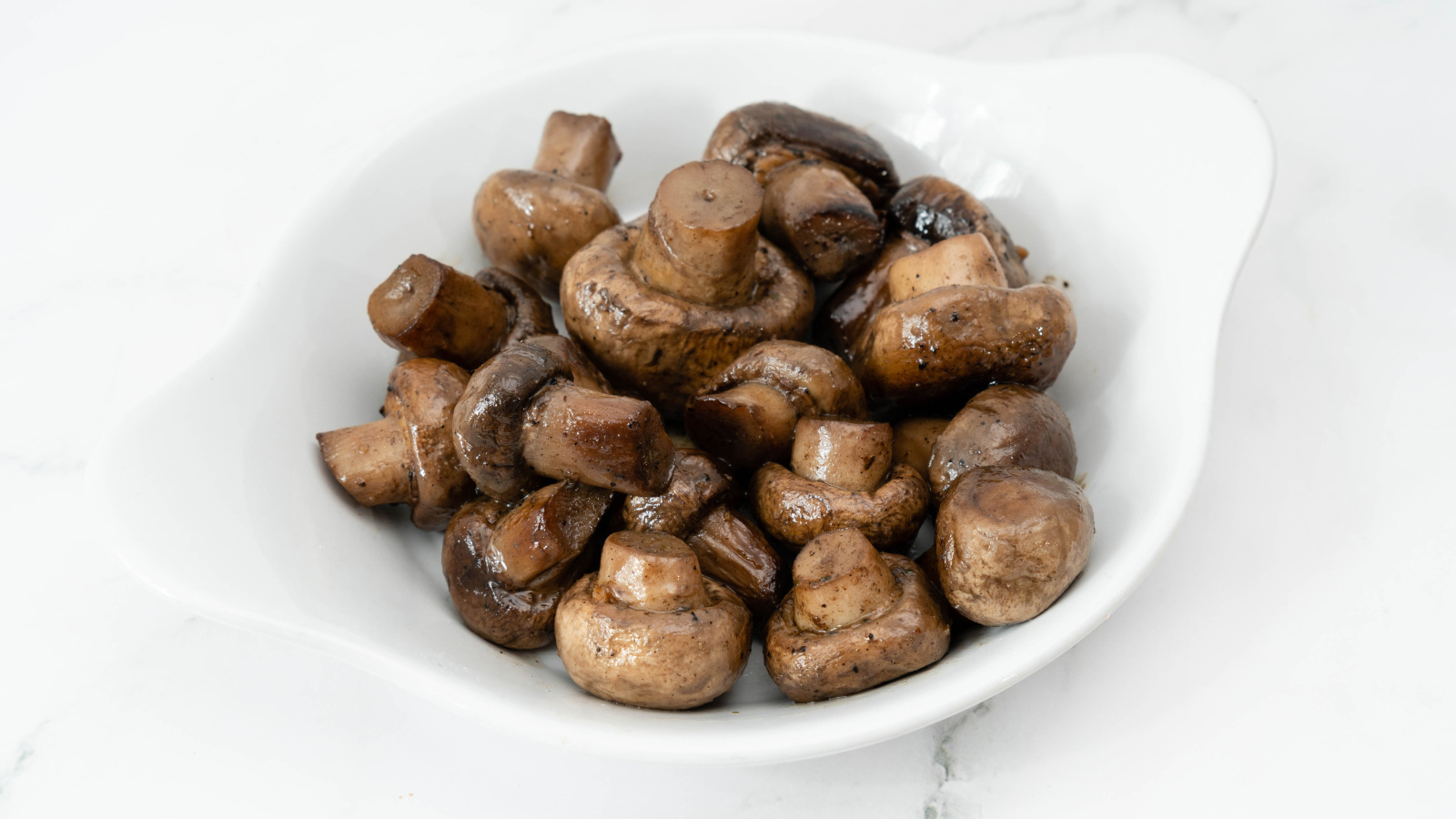 Жареные целые грибы шампиньоны на белом фоне