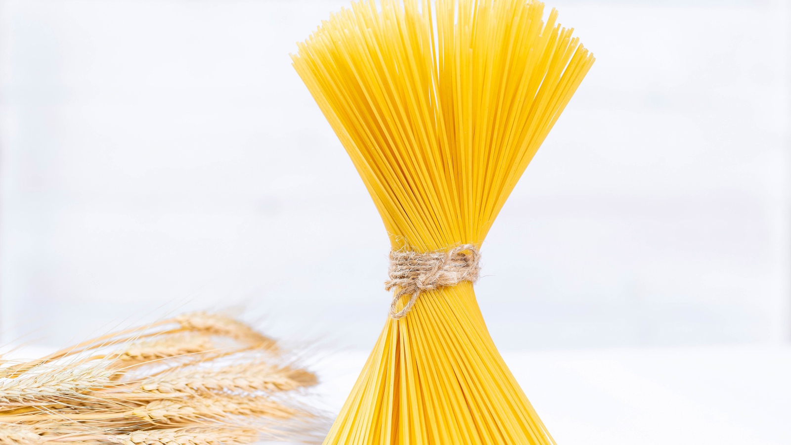 Спагетти перевязаны ниткой на белом фоне