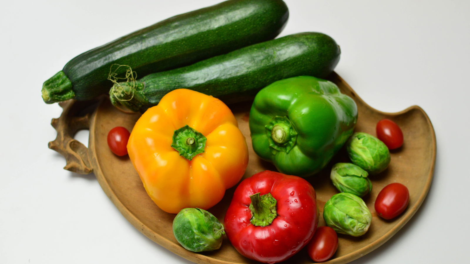 Сладкий перец, кабачки, помидоры и брюссельская капуста на сером фоне