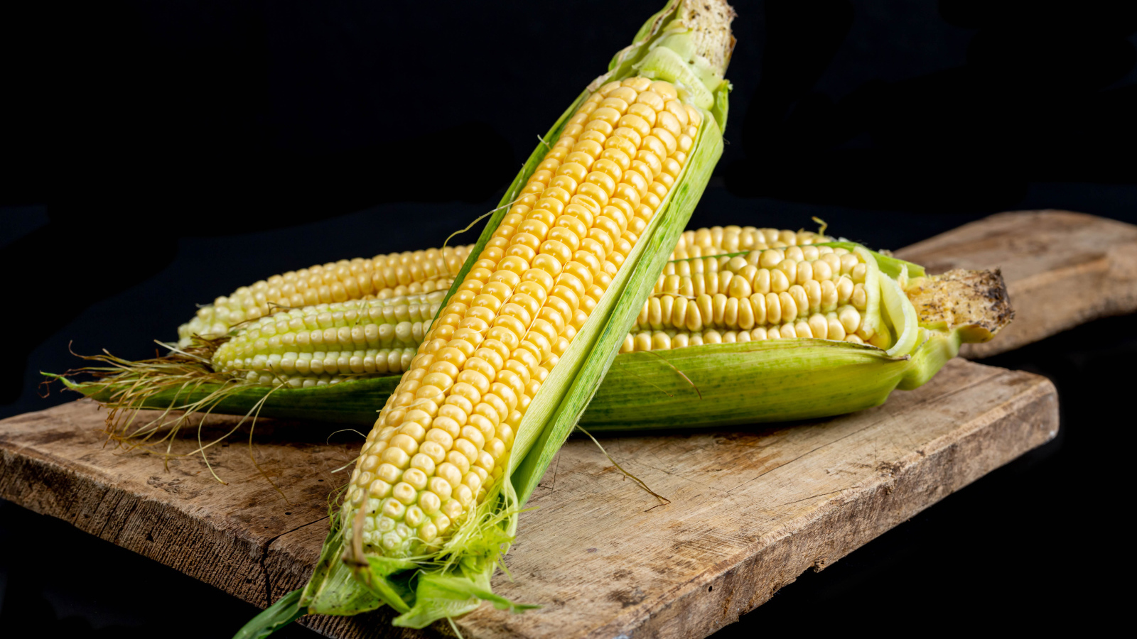 Два початка кукурузы на деревянной доске 