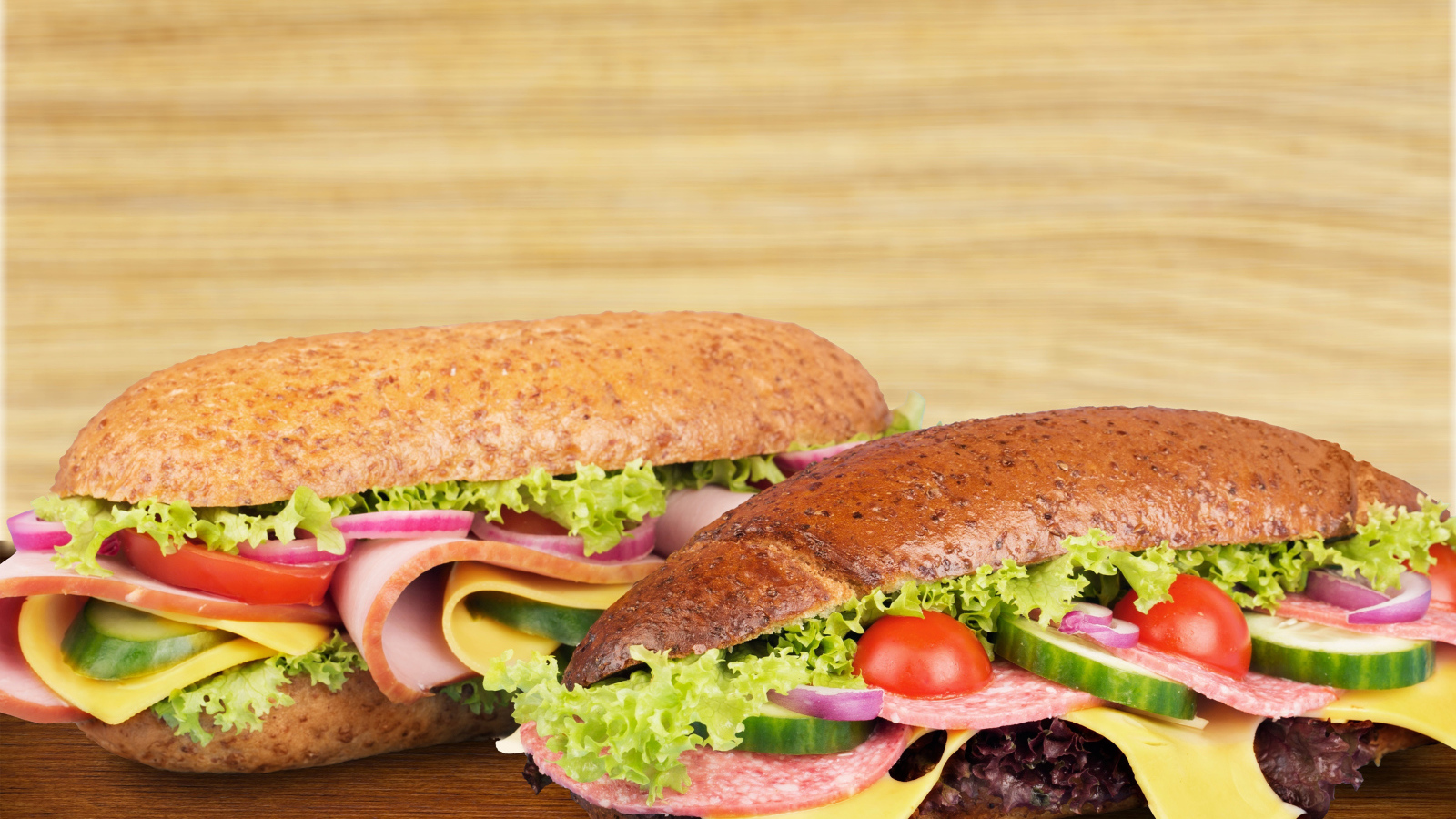 Два вкусных бутерброда с овощами и колбасой на столе 