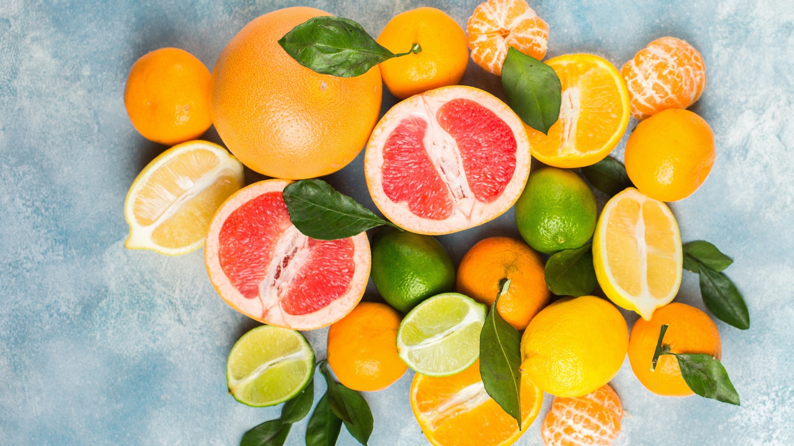 Аппетитные цитрусовые фрукты с зелеными листьями