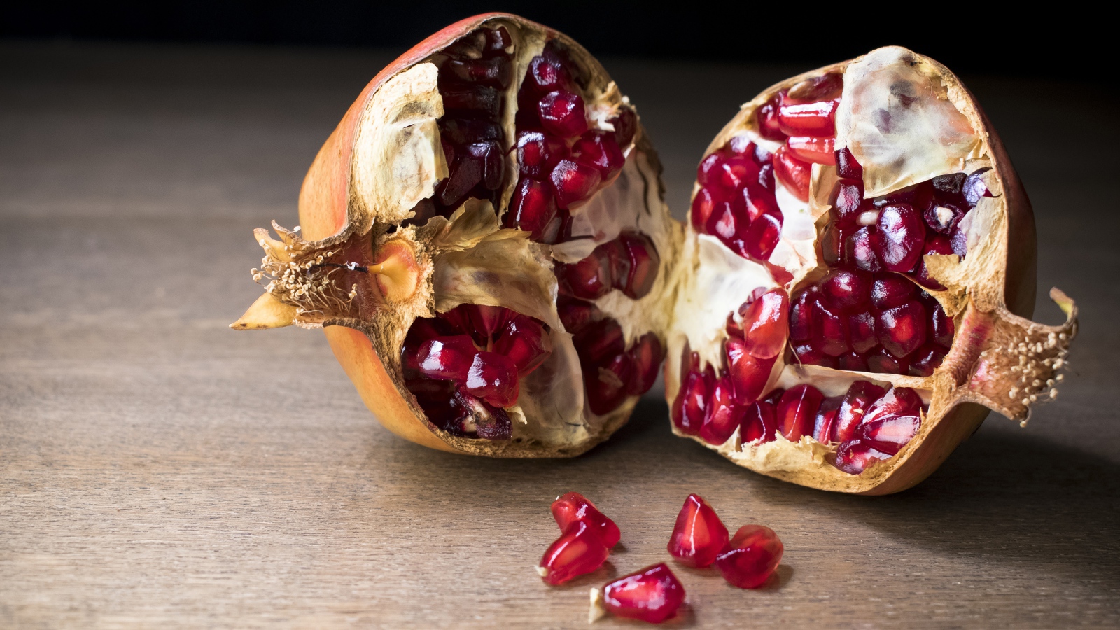 Разломанный красный гранат на столе 