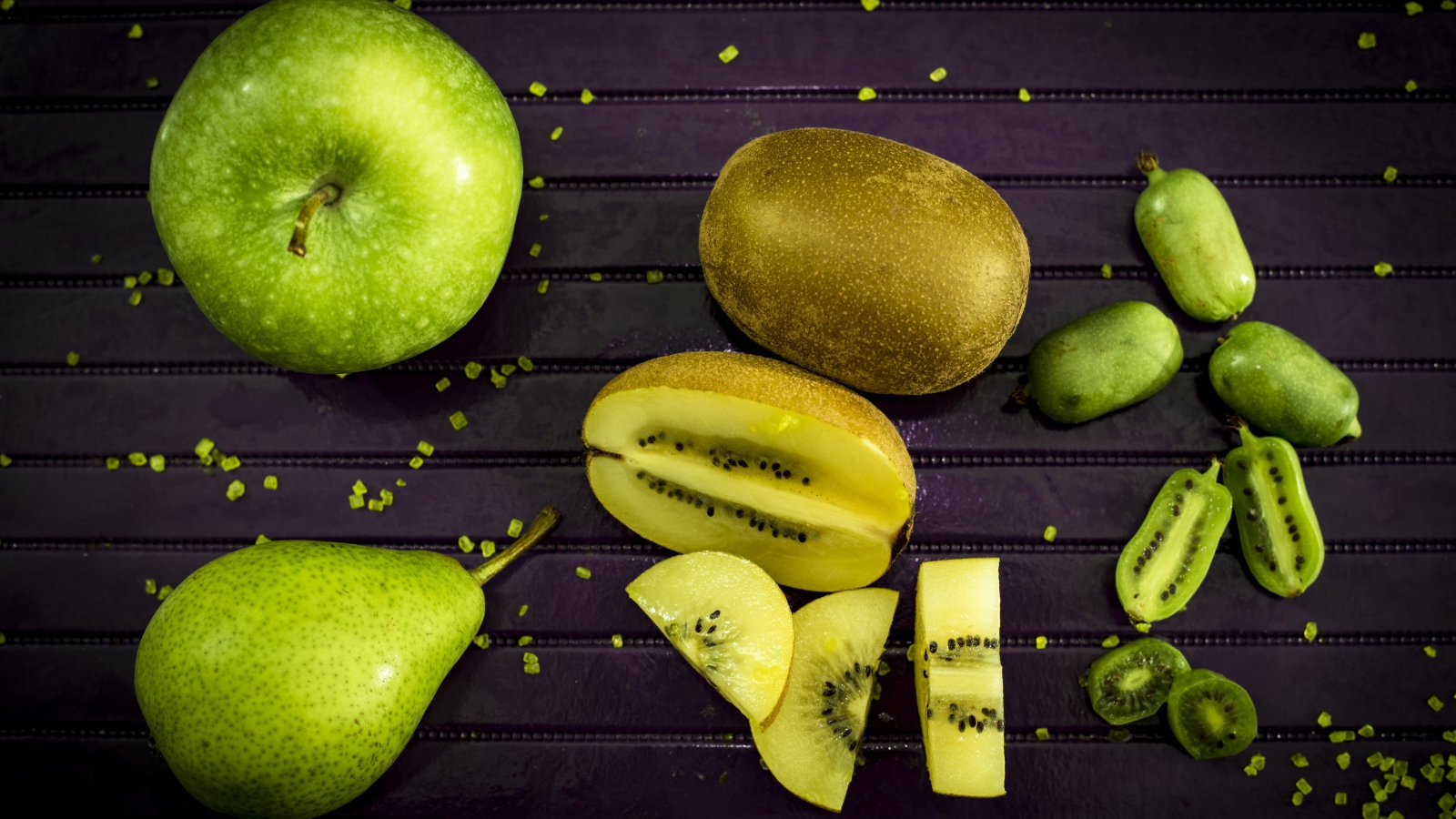 Green apple on the table with pear, kiwi and feijoa