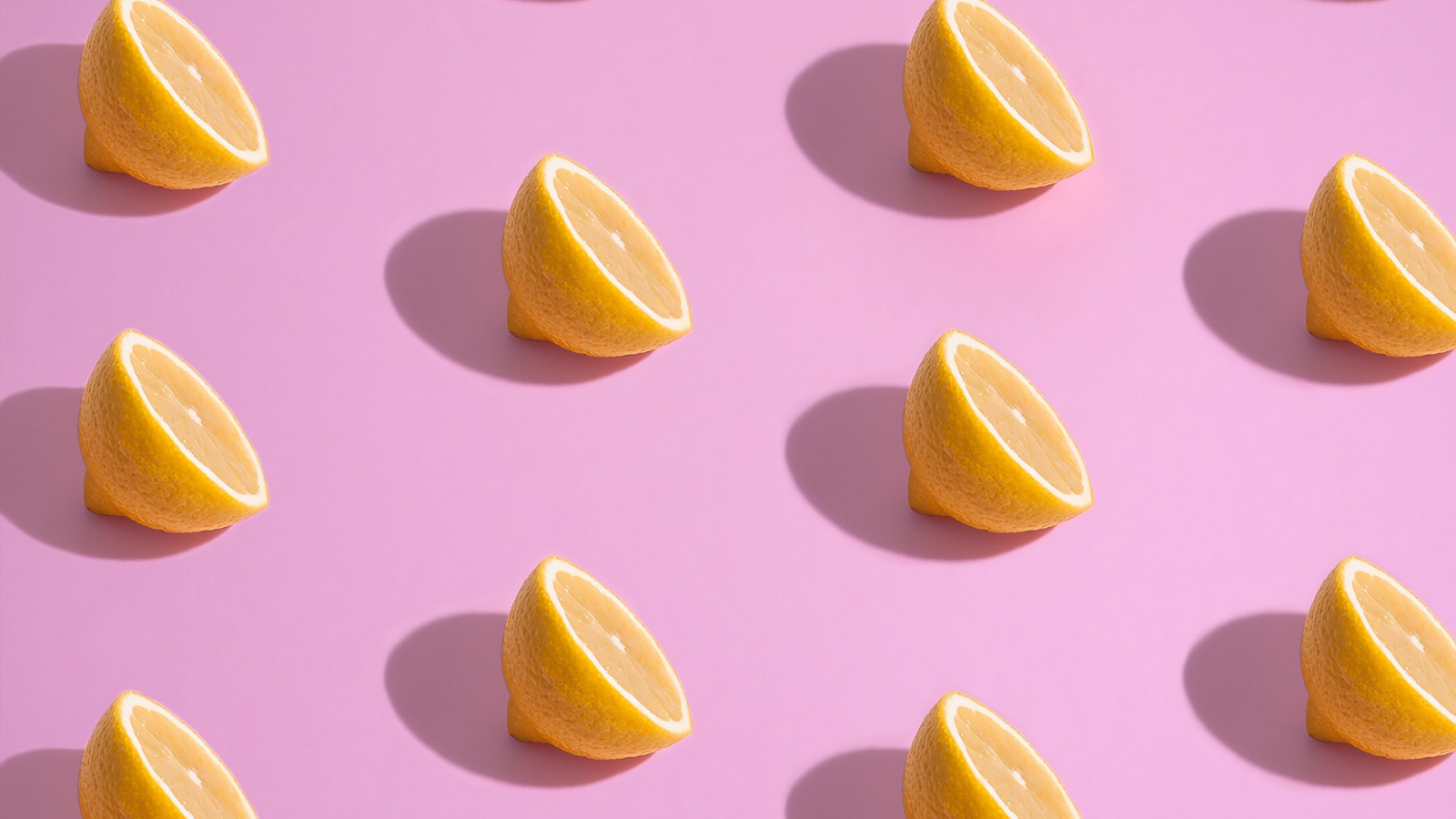 Половинки лимона на розовом фоне