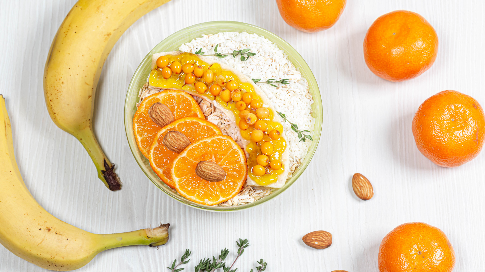 Мюсли с облепихой, бананом и апельсином на столе с фруктами