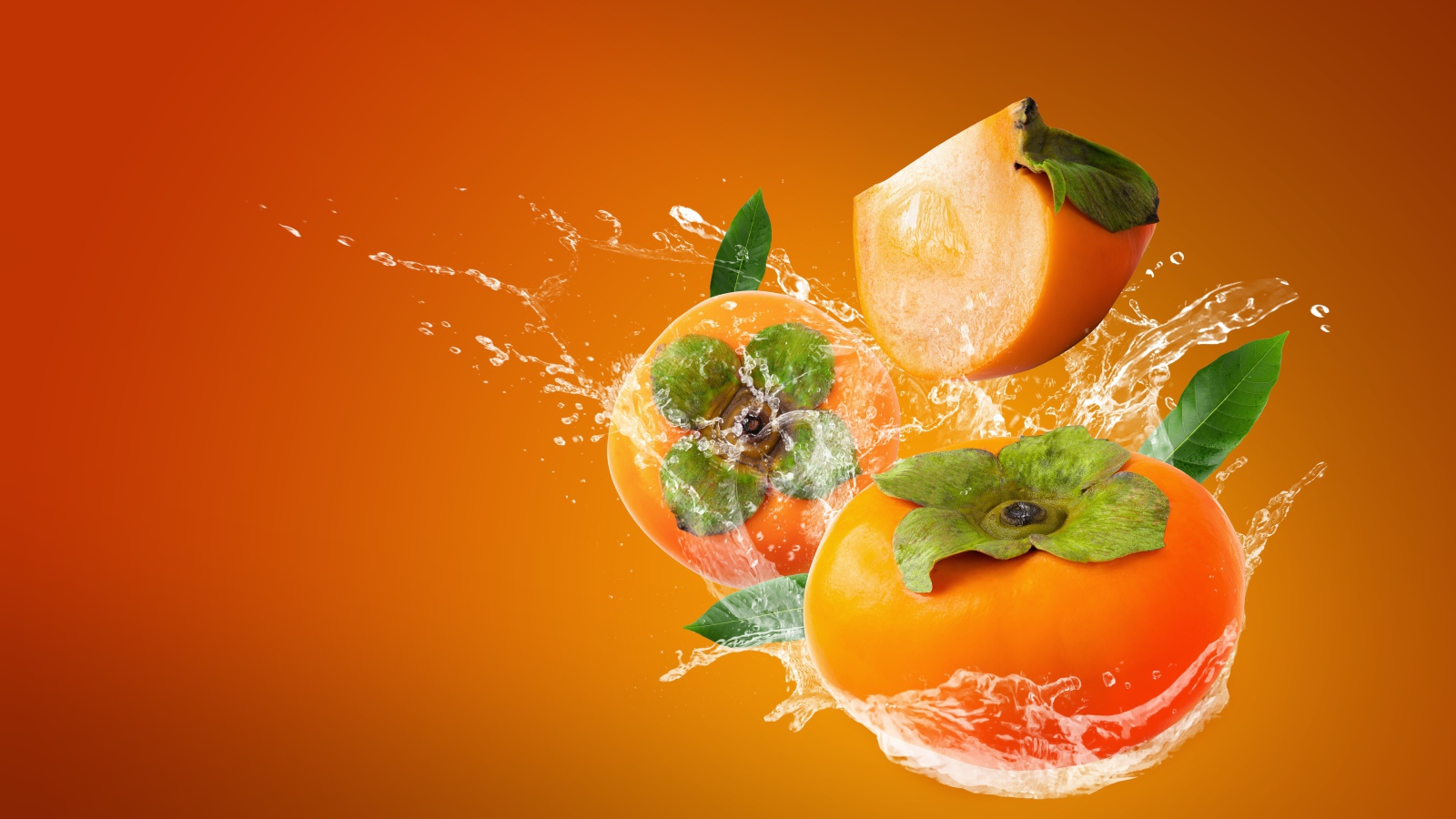 Хурма в брызгах воды на оранжевом фоне