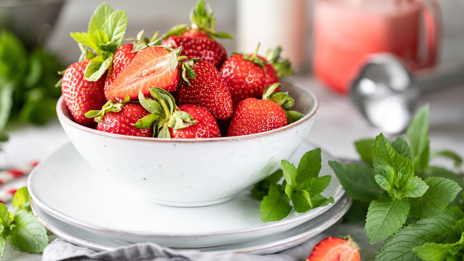 Спелая клубника с мятой на столе в белой тарелке 