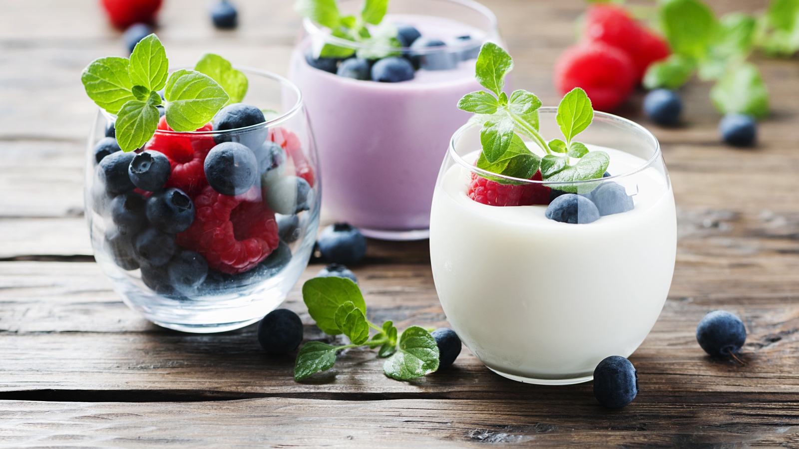 Вкусный йогурт с ягодами черники и малины на столе 