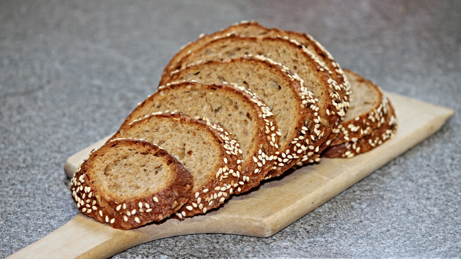 Свежий хлеб нарезан на доске на столе 