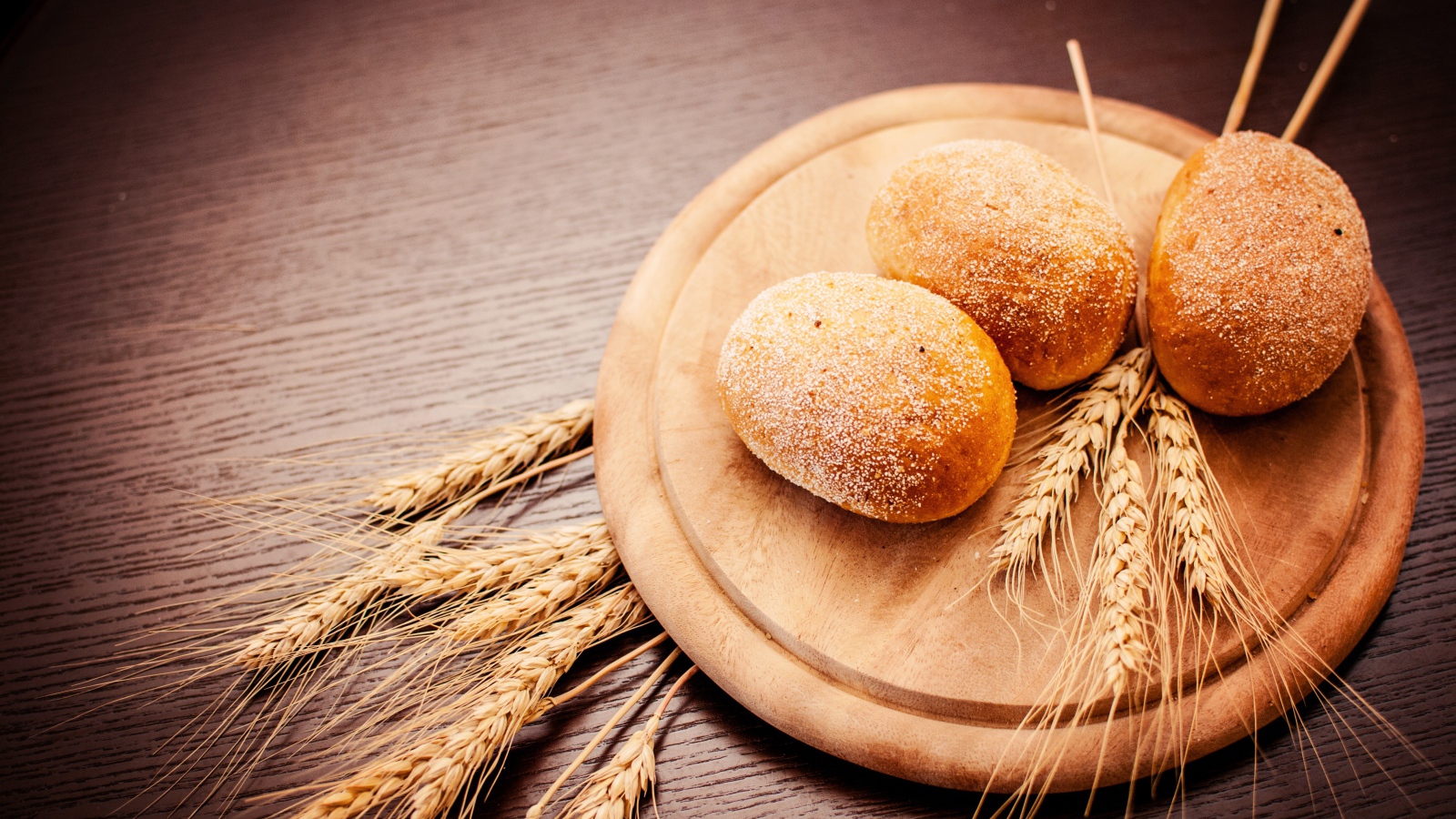 Свежий хлеб с колосьями пшеницы на доске