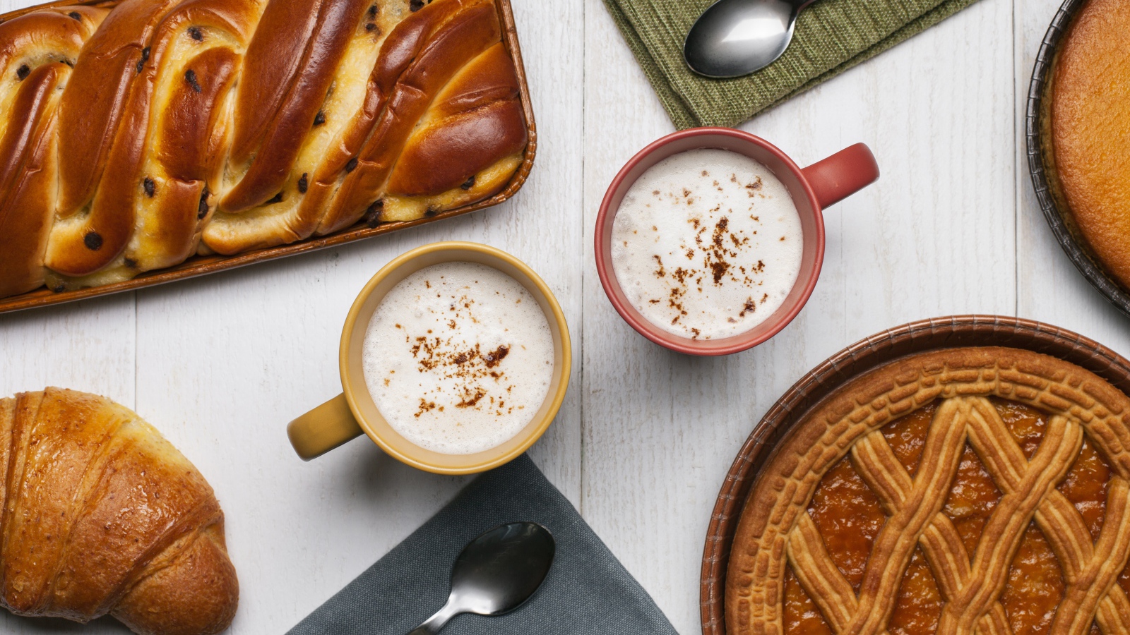 Свежая выпечка и две кружки молока на столе