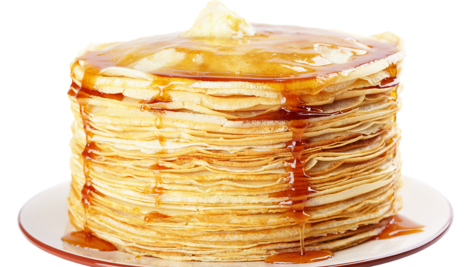 Тонкие блины с медом на тарелке на белом фоне