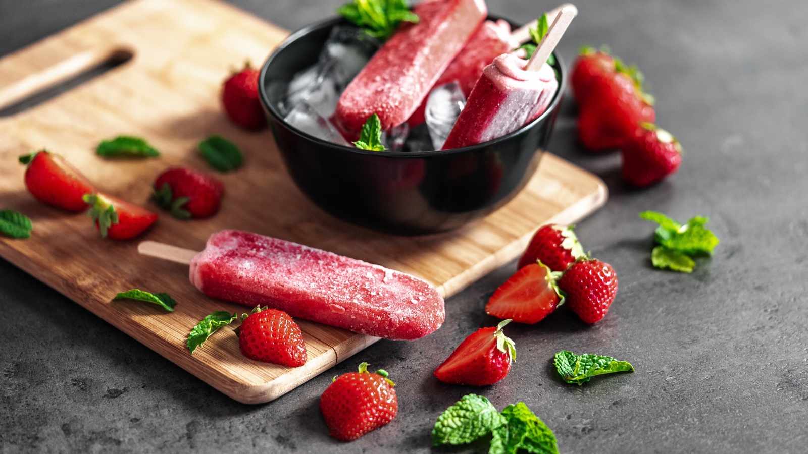 Ягодное мороженое с клубникой и мятой на столе 