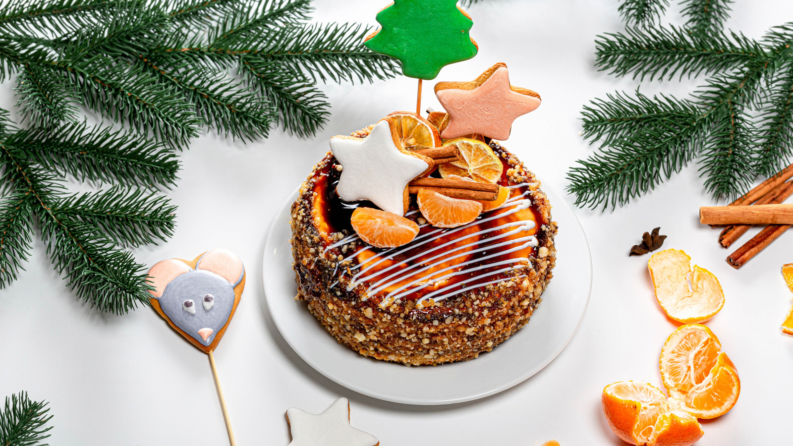 Торт с мандаринами и печеньем на столе с еловой веткой