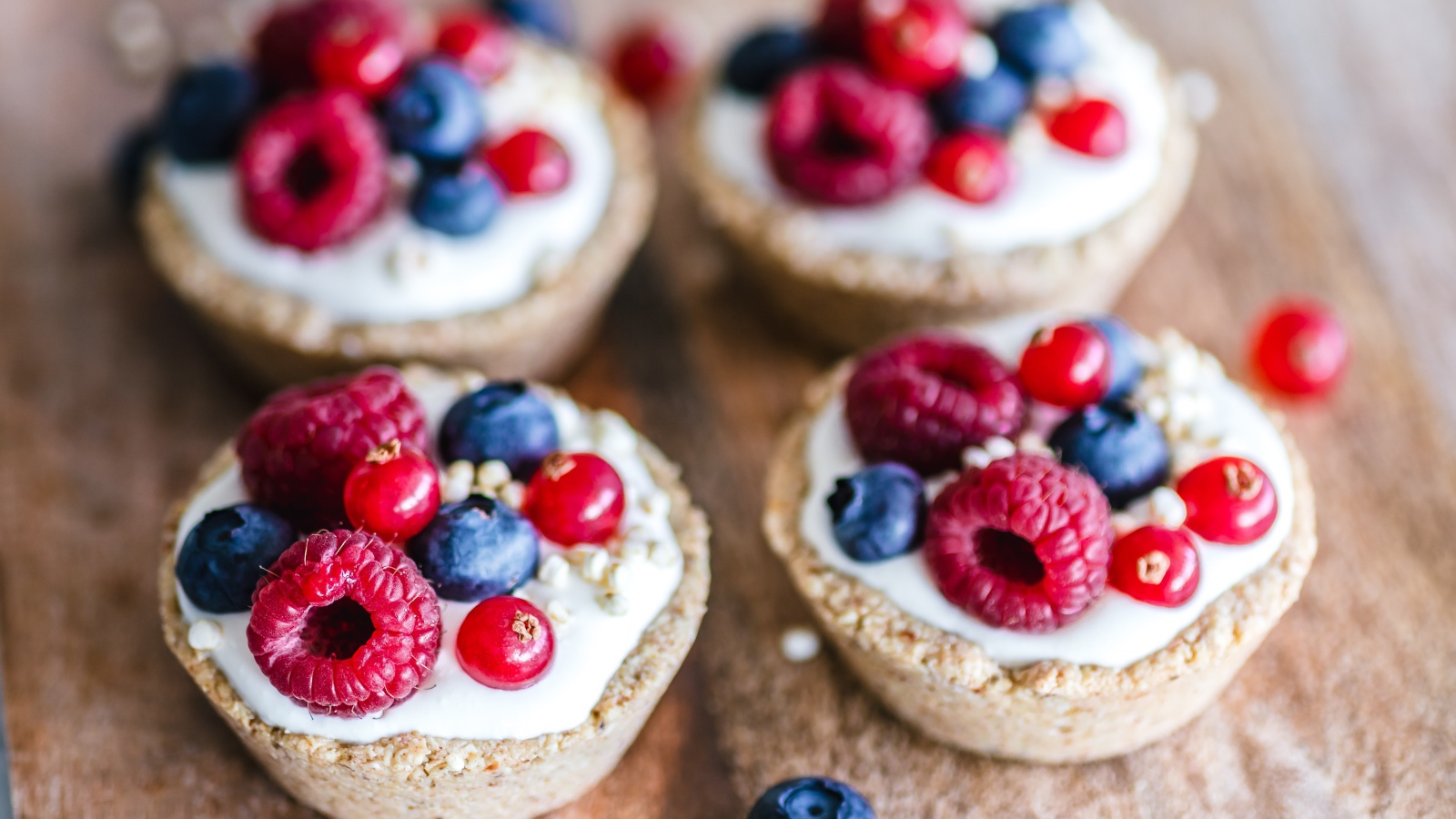 Пирожные с кремом и ягодами на столе крупным планом