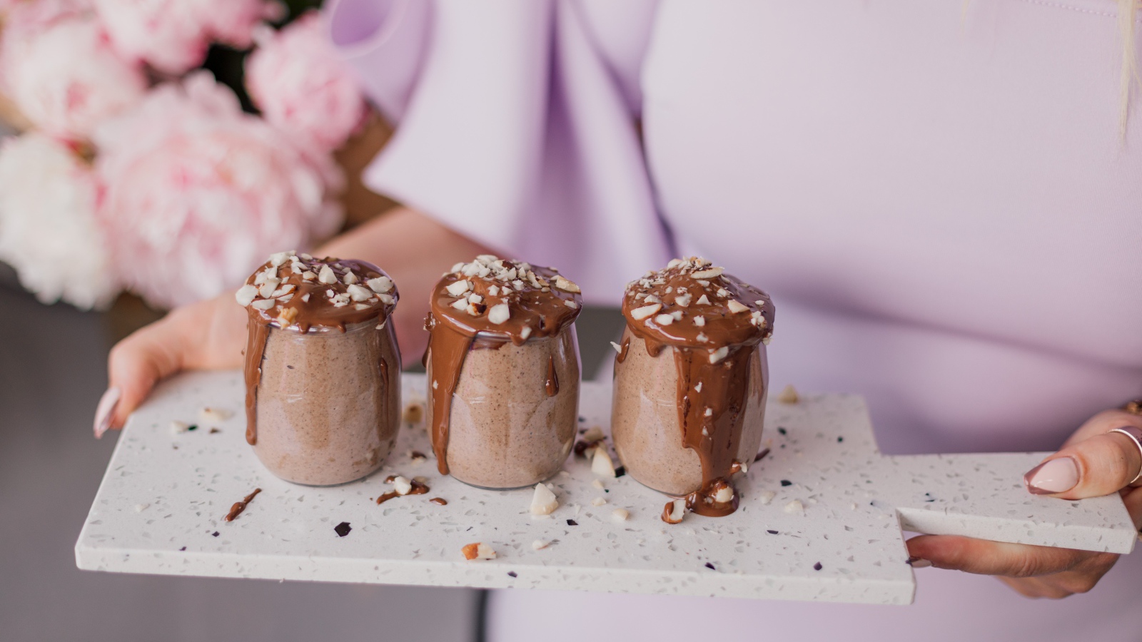 Шоколадный десерт в банках в руках у девушки