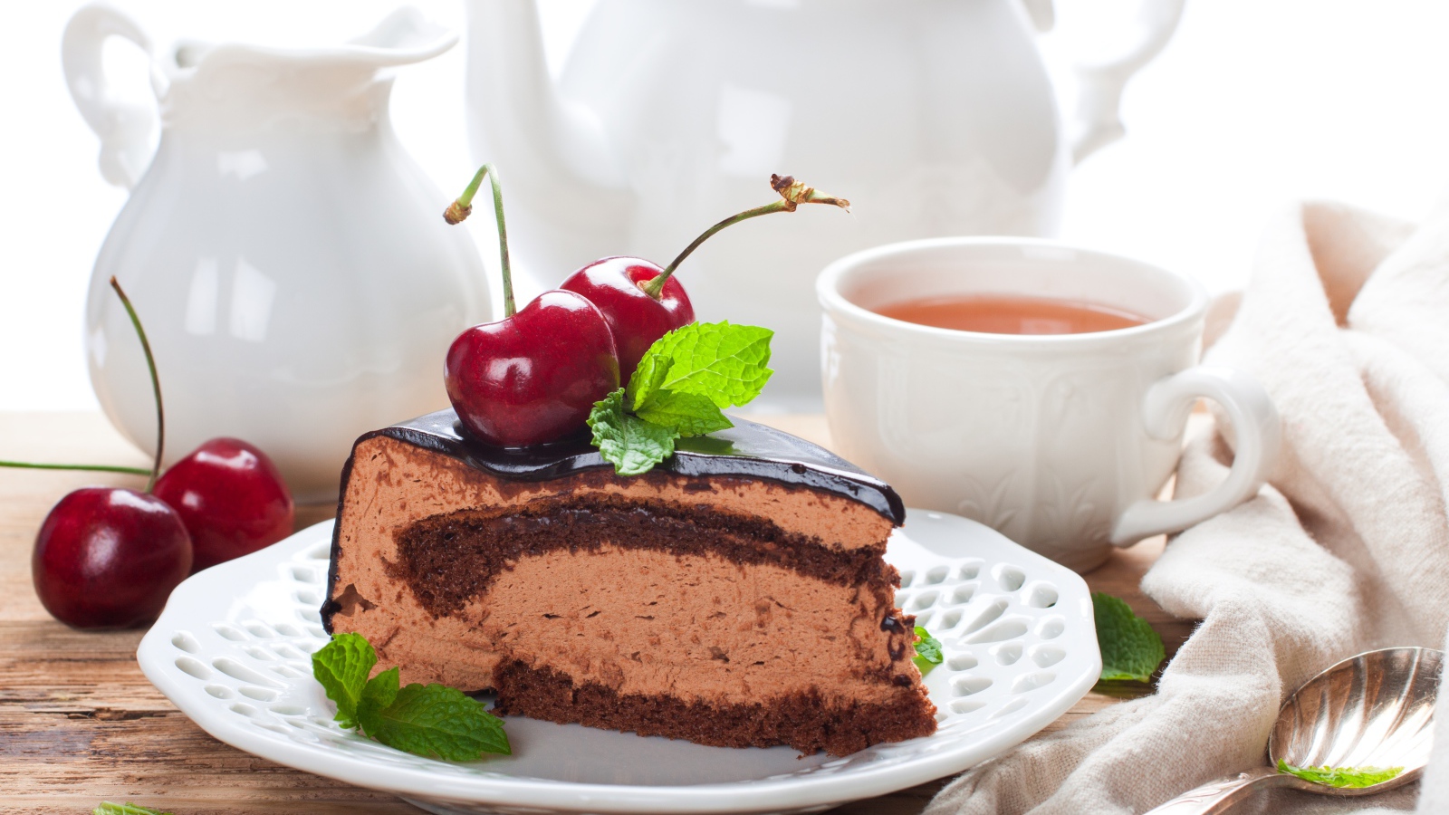 Торт с суфле в шоколаде с ягодами черешни на столе с чаем