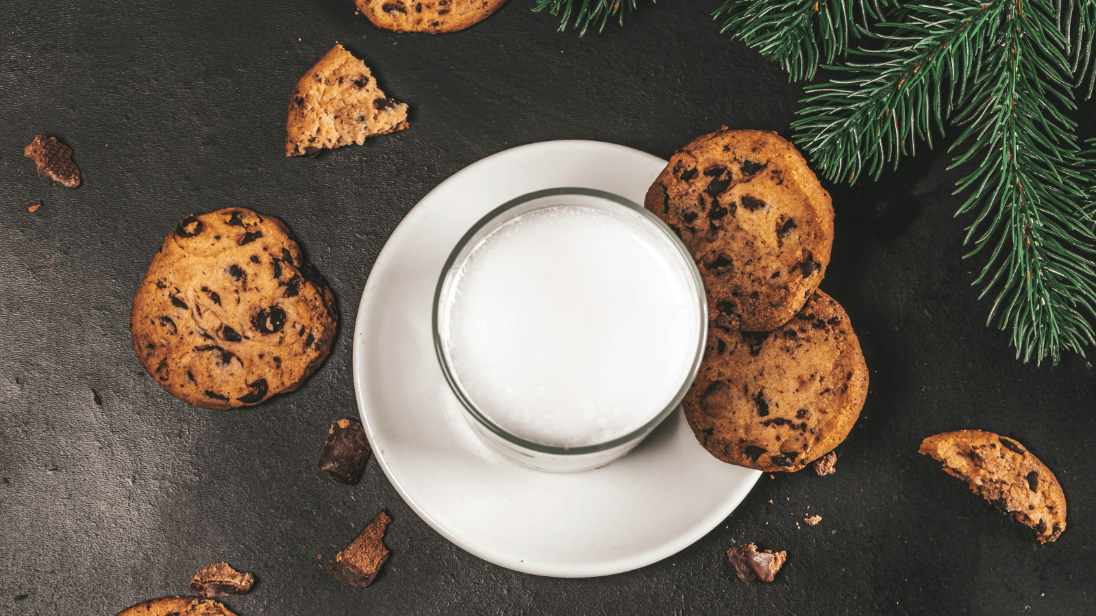 Печенье с шоколадом на столе со стаканом молока 