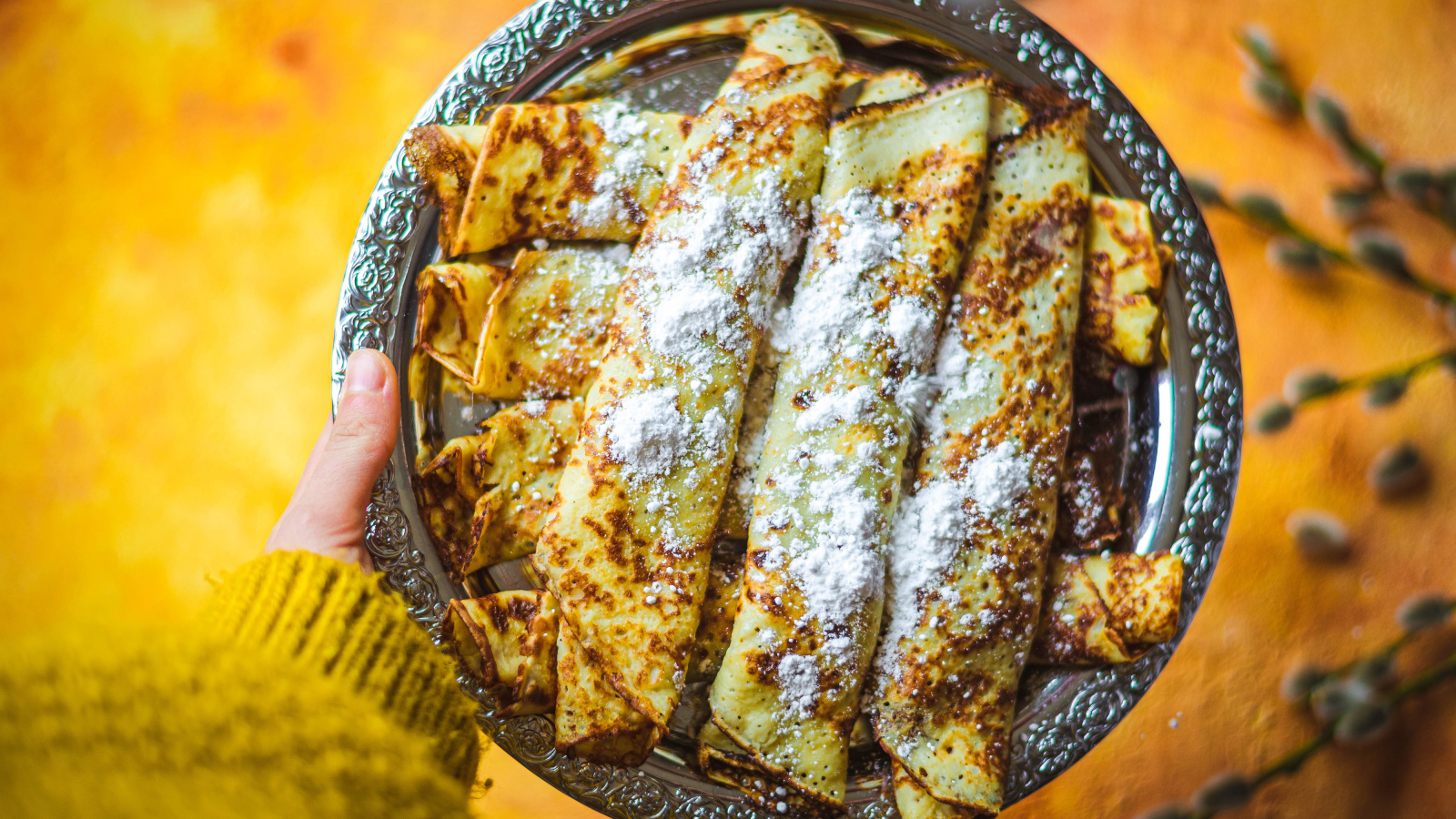 Вкусные тонкие блины с сахарной пудрой на блюде